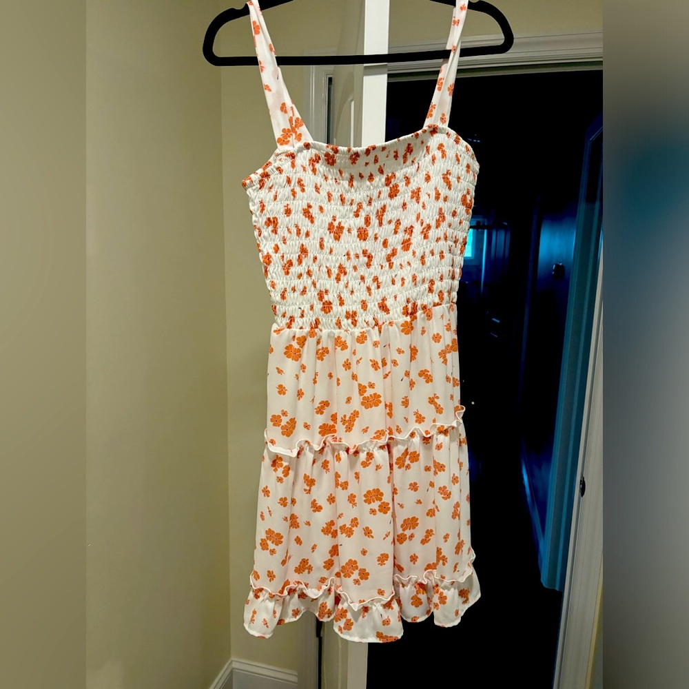 Mid size white dress with pink flowers. Perfect for a summer event.